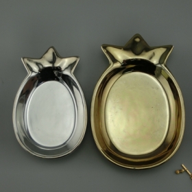 metaliczne naczynie ze złotej i srebrnej biżuterii ananasowej
